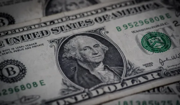 Billetes de dólar y peso colombiano sobre una mesa